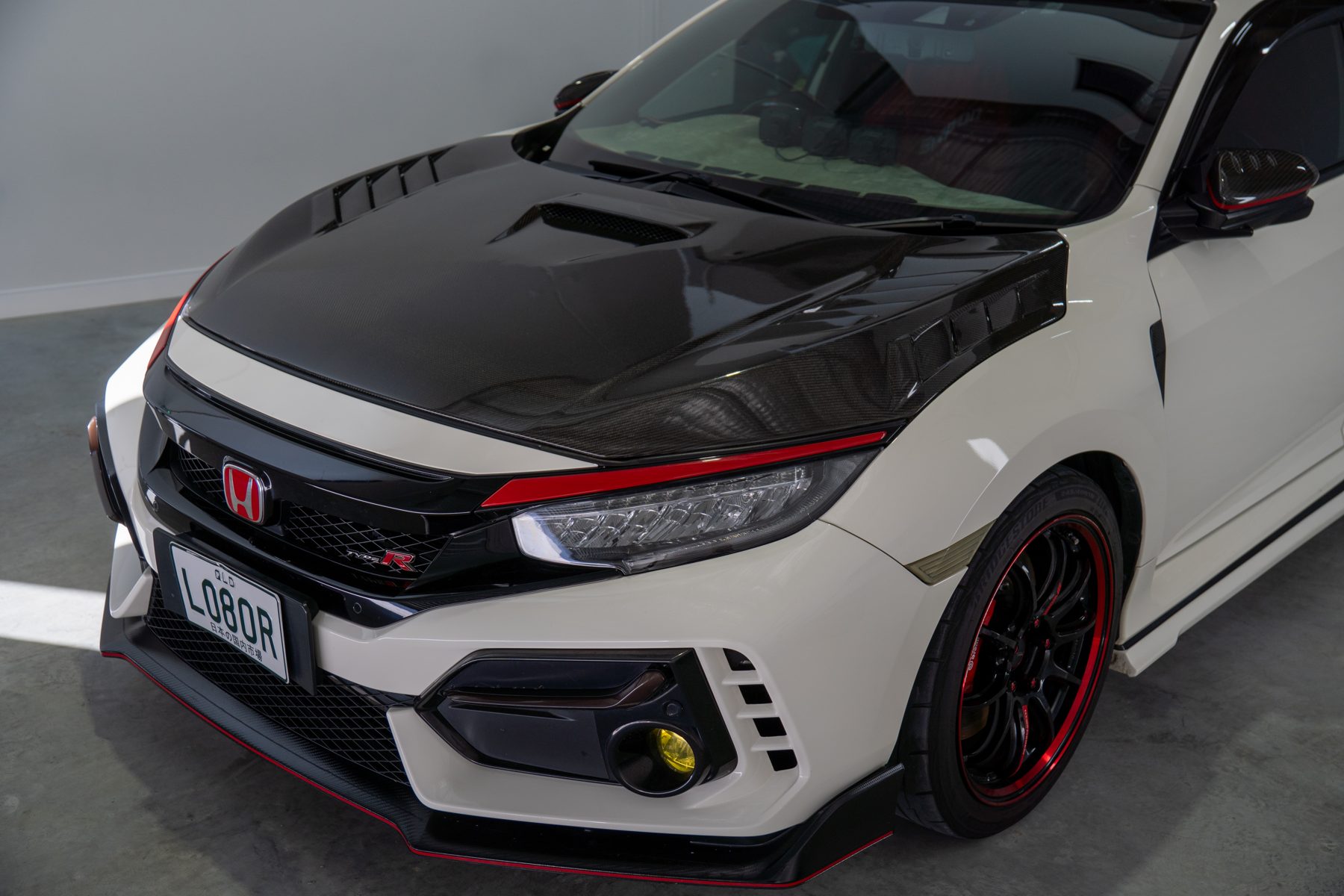 Front three-quarter of the Civic Type R showing the carbon bonnet and red trim
