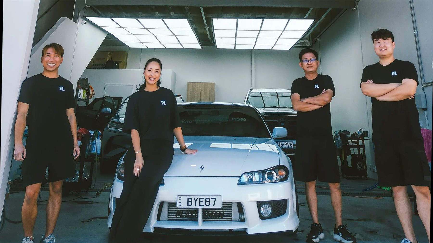 The Next LVL Protection team in the studio with a white coupe