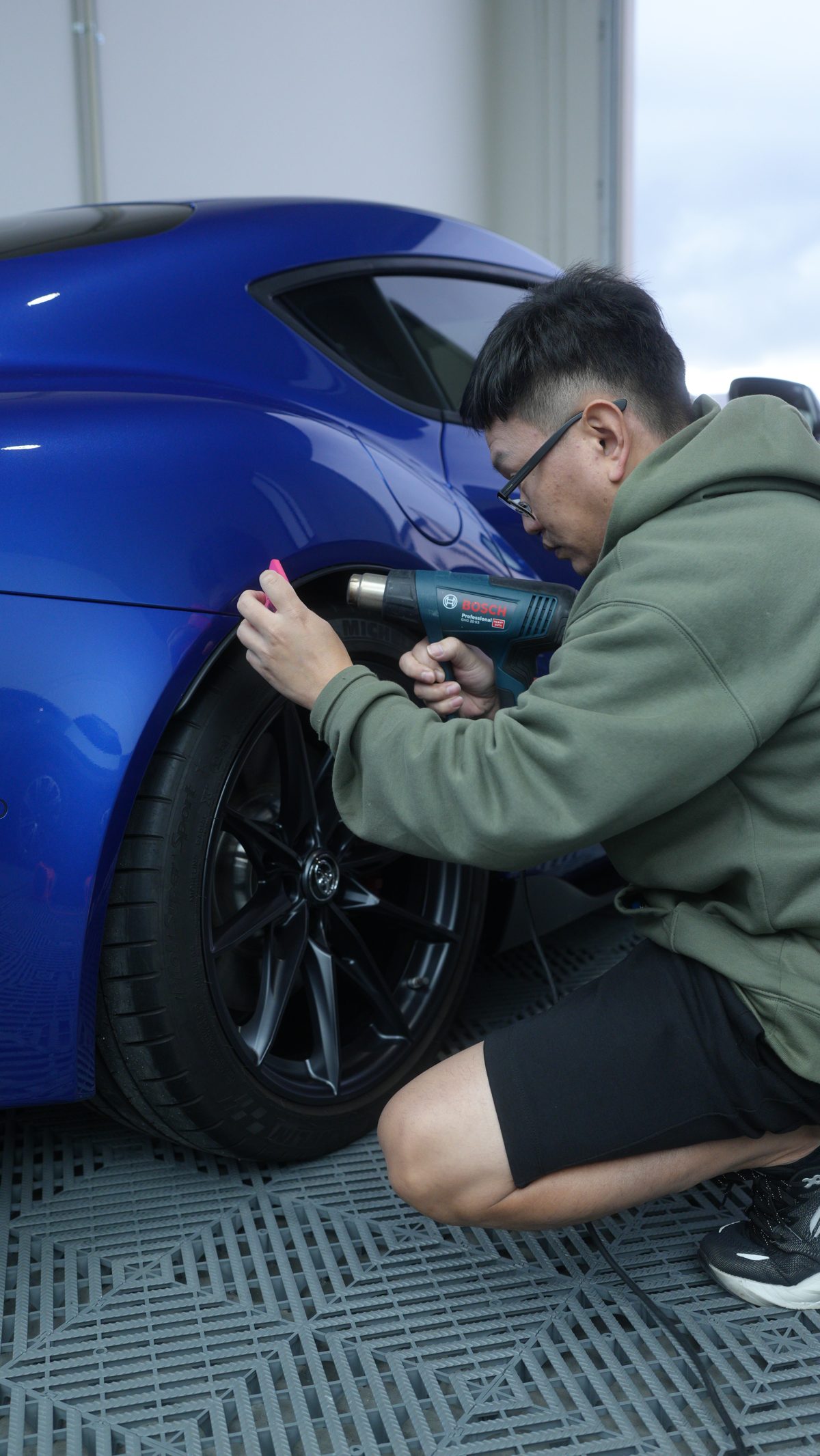 Installer heat-forming film around a rear wheel arch